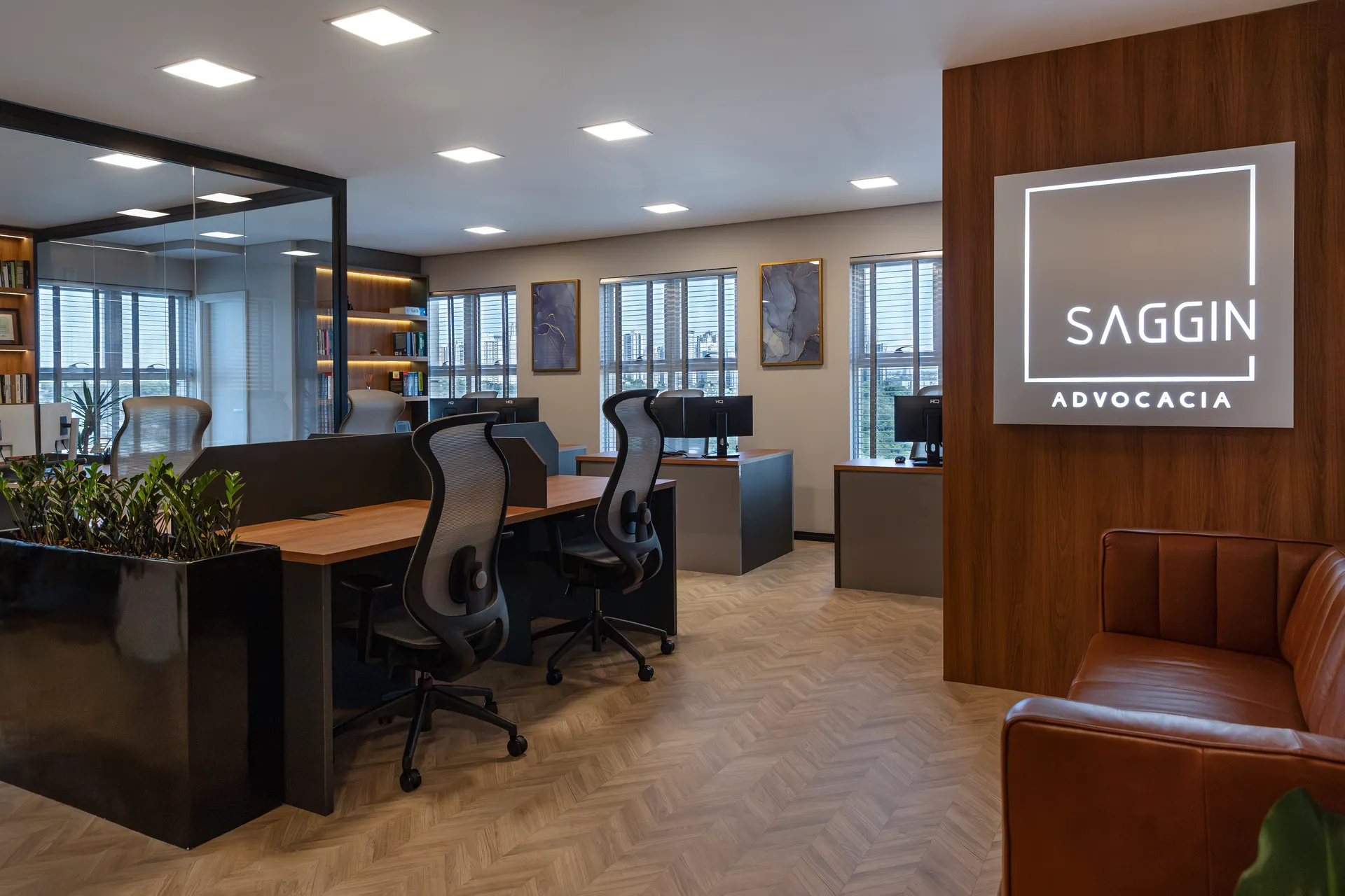 Interior do escritório Saggin Advocacia em Londrina, com painel iluminado da marca