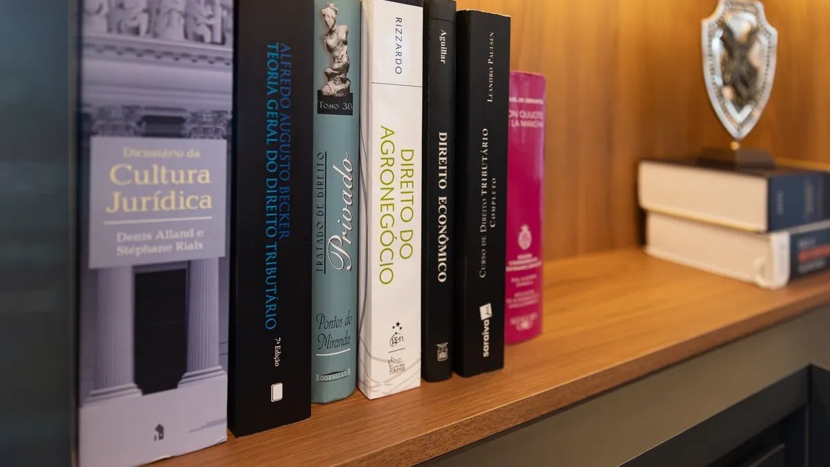Estante com livros jurídicos na biblioteca do escritório da Saggin Advocacia